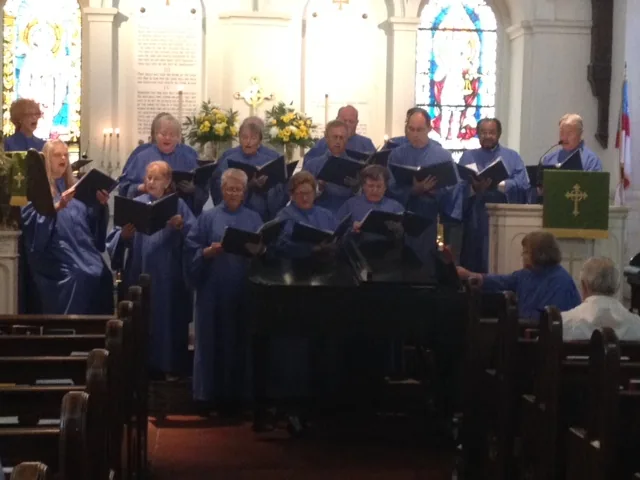 The choir in blue robes singing before the altar
